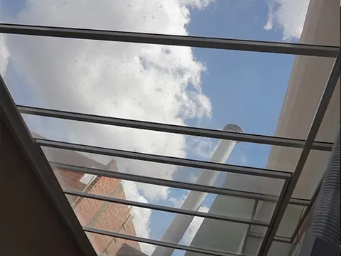 Cobertura de vidro fixa sobre varanda gourmet com estrutura em alumínio